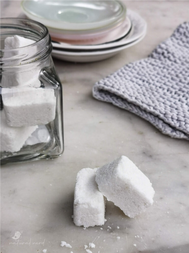 diy dishwasher tablets on marble counter with dishes in the background