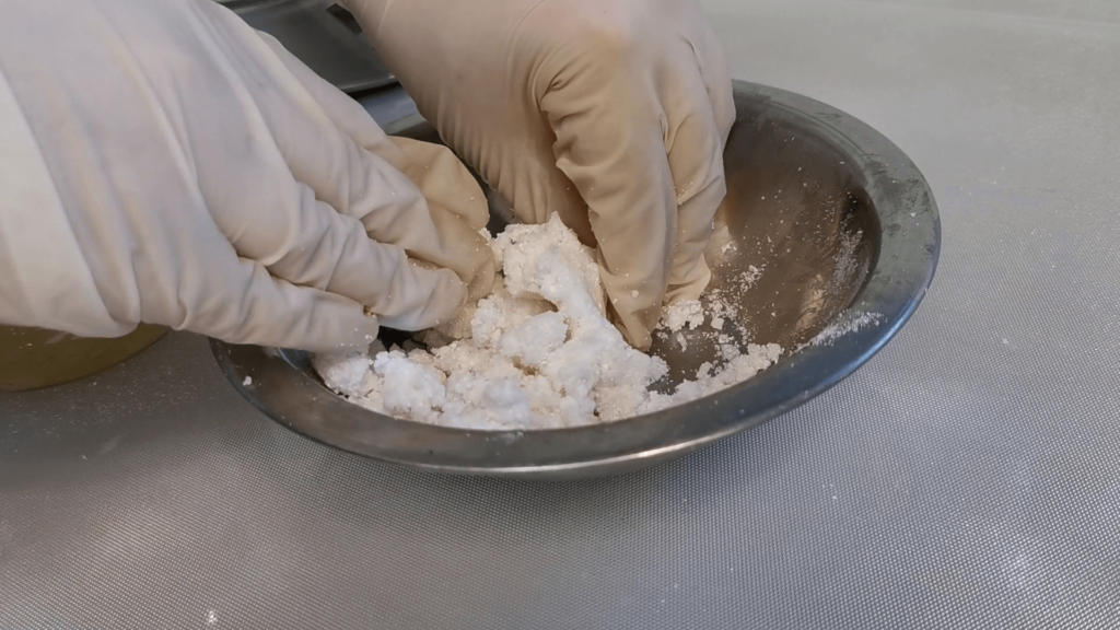 combining soap and dry ingredients with hands to make a mallealble dough
